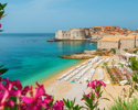 Beautiful View Of Banje Beach And Old Town Of Dubrovnik With Summer Flowers In Croatia, Europe. Summer Vacation Resort